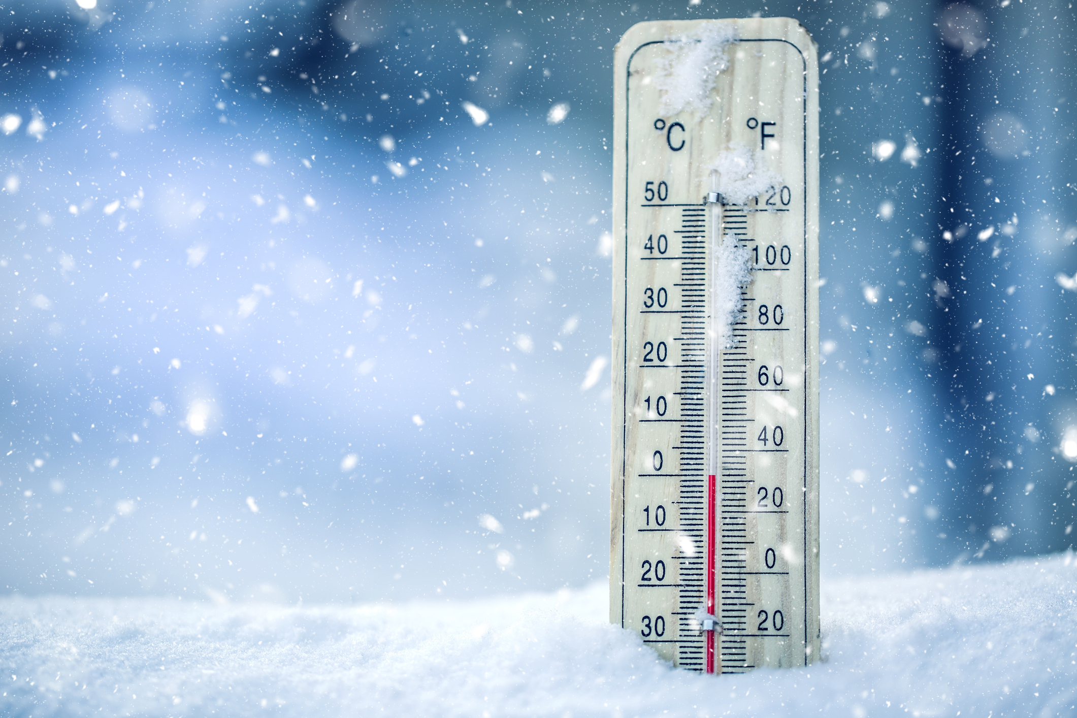 Thermometer on snow shows low temperatures - zero. Low temperatures in  degrees Celsius and fahrenheit. Cold winter weather - zero celsius thirty  two farenheit