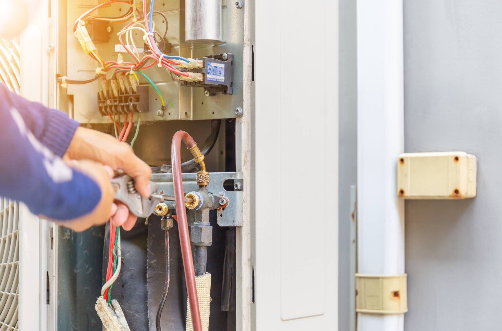 Selective focus of Air Conditioning Repair, repairman on the floor fixing air conditioning ...